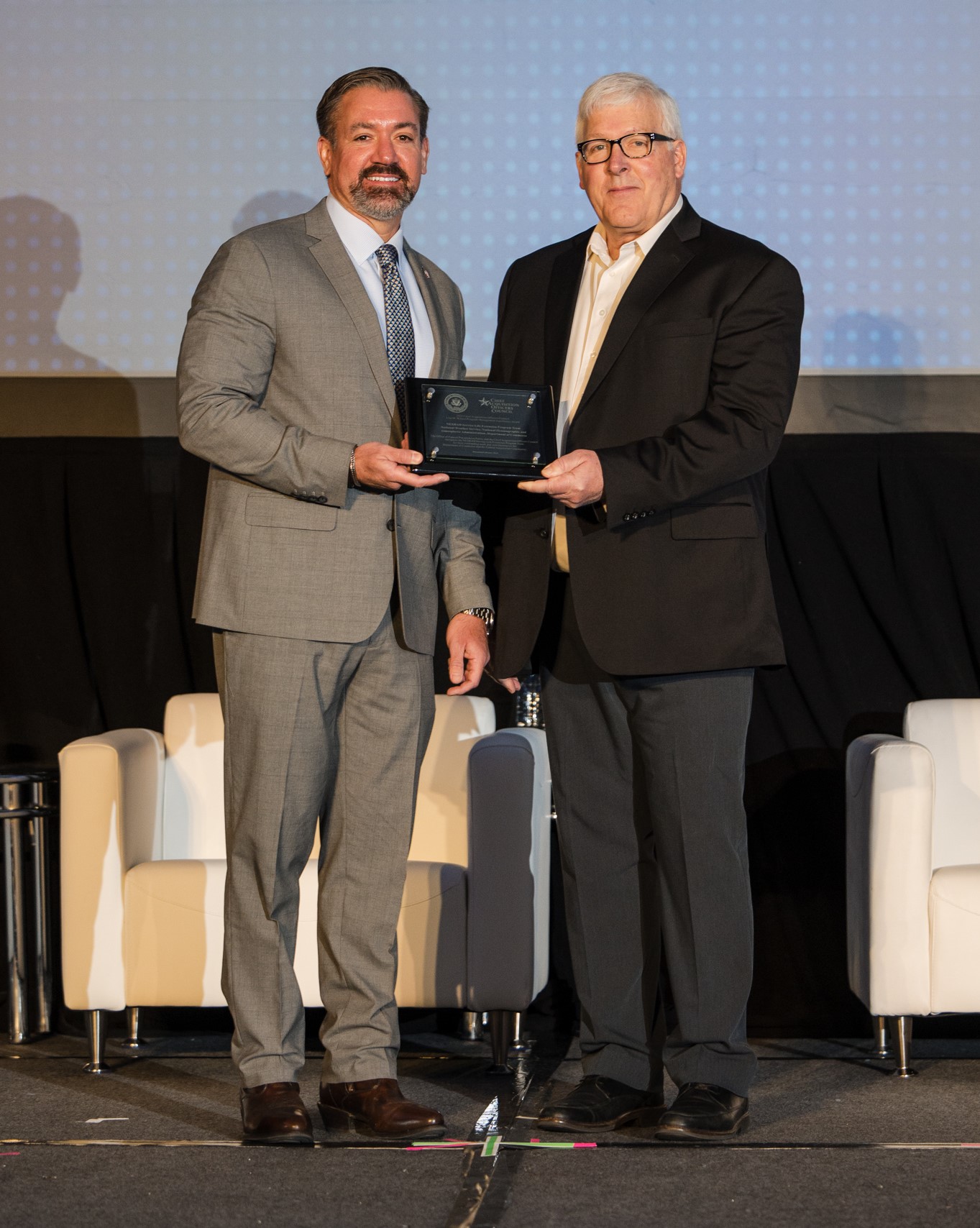 Dr. Kevin Rhodes, Administrator of the Office of Federal Procurement Policy (left), presents Terrance Clark with the Lisa Wilusz Program Management Excellence Award.